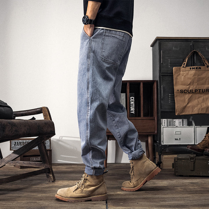 Un homme portant un jean cargo coupe large bleu clair avec des bottes et des poches latérales cargo. Style streetwear décontracté pour homme.