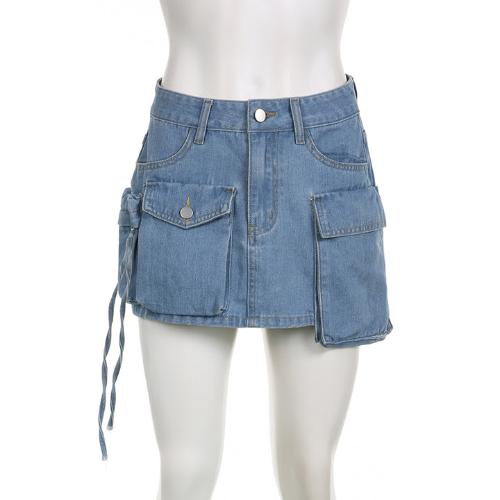 Une mannequin porte une jupe cargo en jean bleu avec plusieurs poches. Coupe droite, silhouette féminine et urbaine. Disponible en tailles S à L.