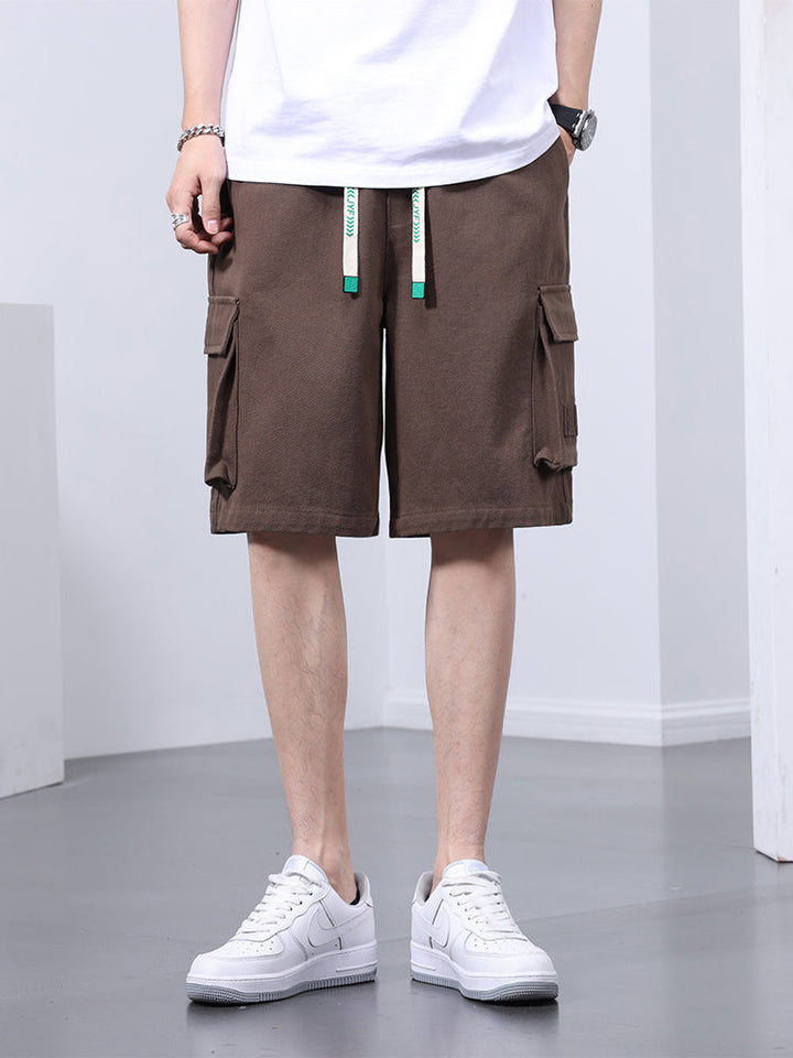 Un homme portant un short cargo marron clair et des baskets blanches