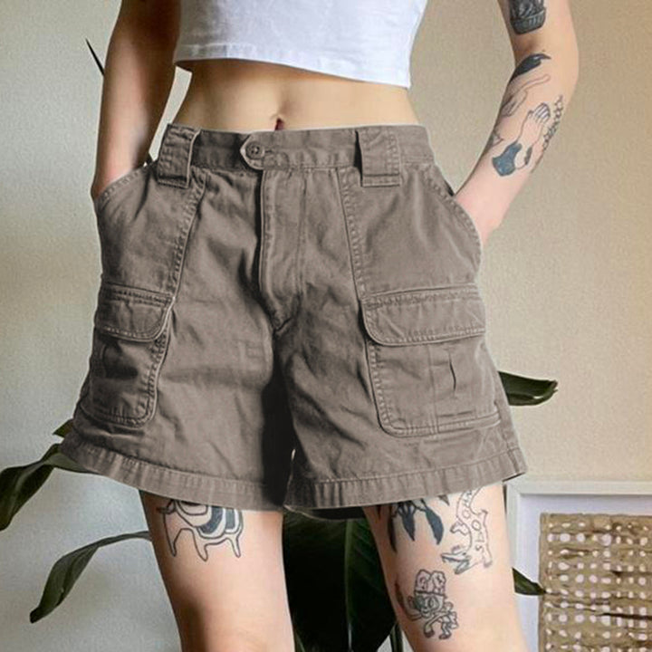 Une femme portant un short cargo évasé mi-long gris avec poches latérales. Parfait pour un look décontracté et stylé. Disponible du S au L.