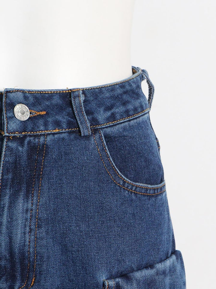 Un gros plan d'un jean cargo baggy taille basse bleu pour femme avec des poches cargo sur les jambes.