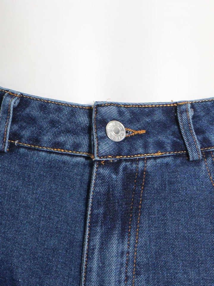 Un jean cargo baggy taille basse pour femme, bleu. Jambes larges et évasées, nombreuses poches cargo. Style streetwear tendance.