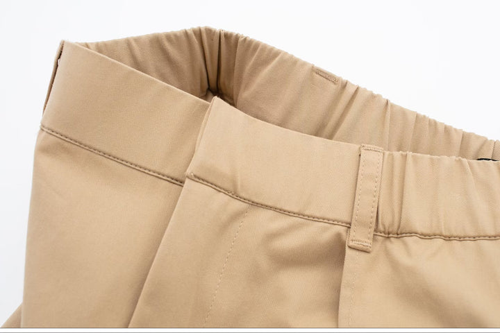 Jupe short cargo beige pour femme - Vue rapprochée d'un tissu beige avec poches cargo dépassant légèrement de la jupe. Hybride élégant d'une mini-jupe évasée et d'un short pour femmes audacieuses. Tailles S à XL.