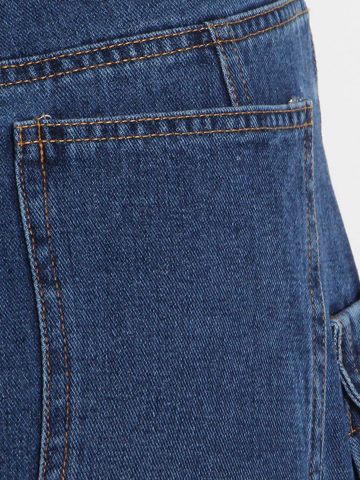 Un gros plan sur une poche de jean cargo baggy taille basse bleu pour femme. Les poches cargo sur les jambes ajoutent une touche unique et audacieuse à ce jean streetwear. Disponible du S au 2XL.