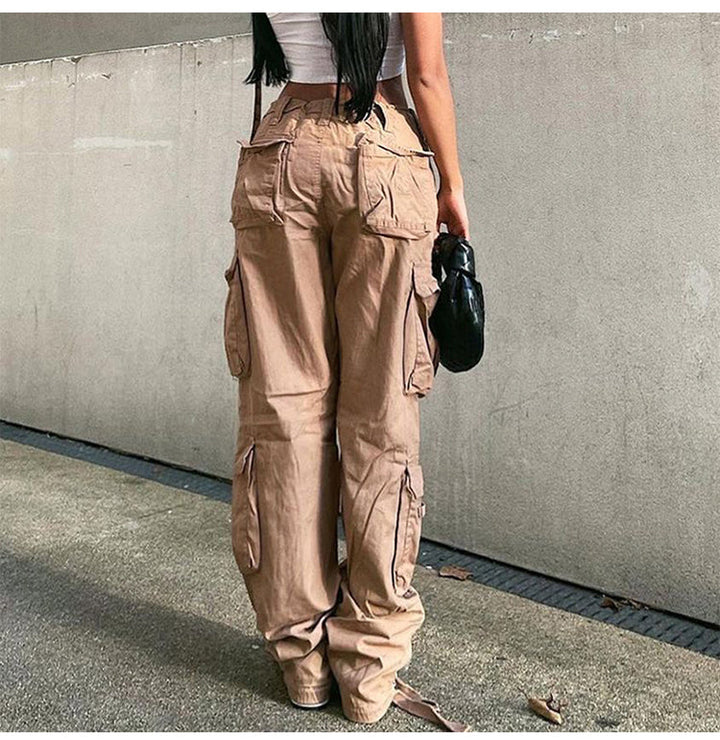 Une femme portant un pantalon cargo camel avec de nombreuses poches. Coupe droite et taille haute pour mettre en valeur votre silhouette. Disponible du S au XL.