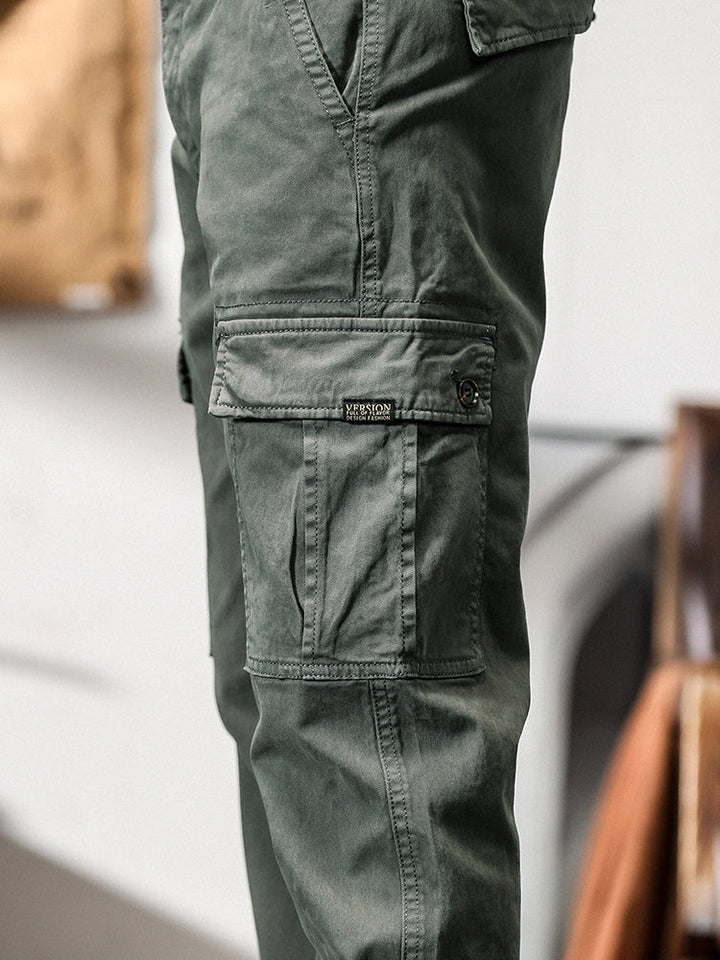 Un gros plan sur le pantalon cargo gris pour homme avec poches cargo et fermeture bouton. Coupe droite, confortable et stylé. Tailles US 28 à 38.