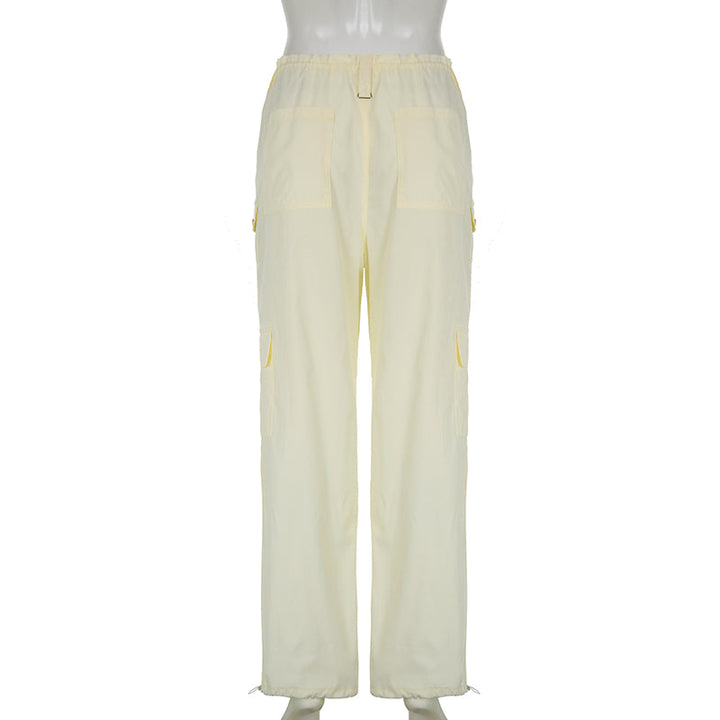 Un mannequin portant un pantalon cargo baggy taille basse élastique pour femme en blanc cassé. Parfait pour un look street et décontracté.