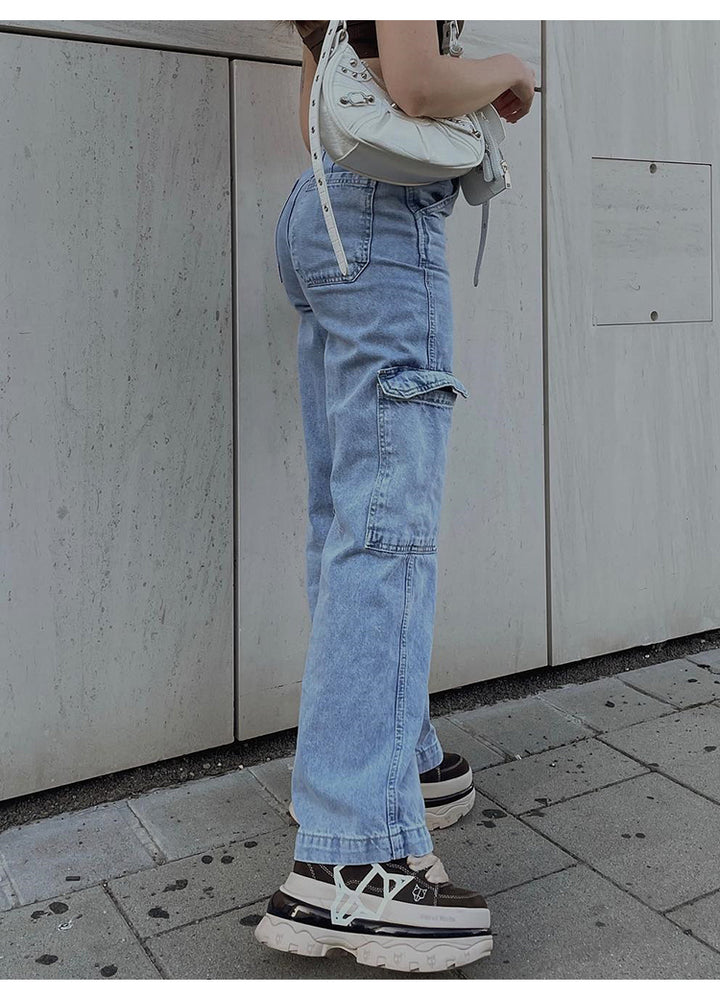 Une personne portant un jean cargo coupe droite taille haute, avec poches cargo latérales. Style féminin et urbain. Disponible du S au XL.