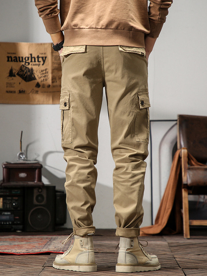 Un homme portant un pantalon cargo beige, coupe droite, avec poches cargo sur les côtés. Confortable et stylé, il est idéal pour diverses occasions.