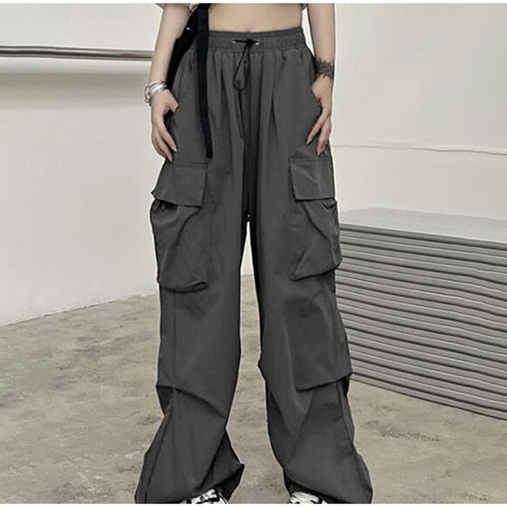 Une personne portant un pantalon gris baggy léger avec des poches latérales. Confortable et stylé, disponible en différentes tailles.