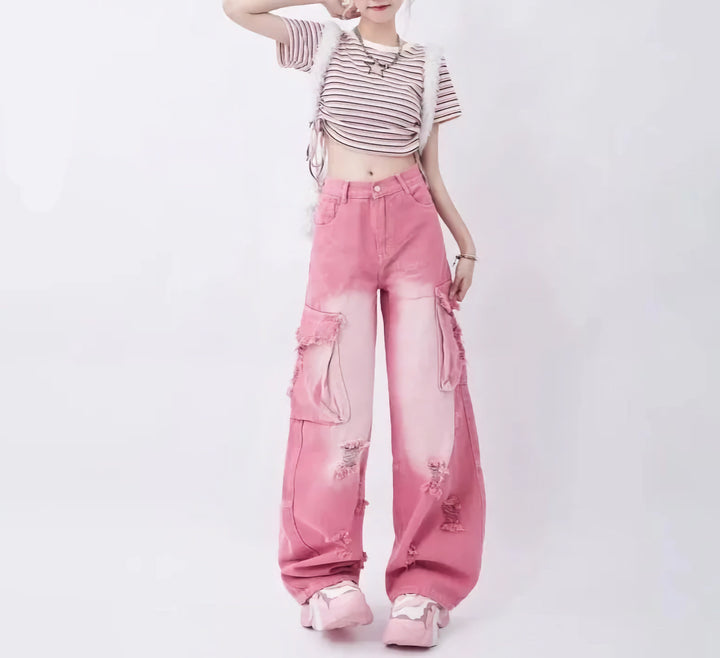 Une femme portant un jean cargo baggy rose délavé et déchiré taille haute, ajoutant une touche urbaine et féminine à ce classique du streetwear.